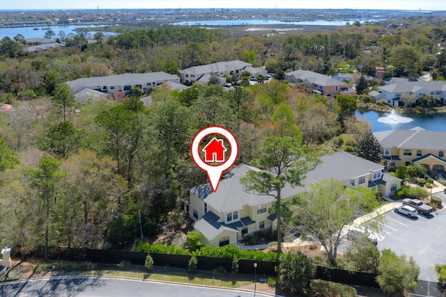 drone / aerial view featuring a residential view, a view of trees, and a water view