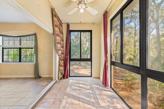 unfurnished sunroom with a ceiling fan