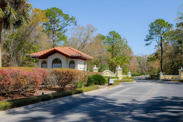 view of road with a gated entry and curbs