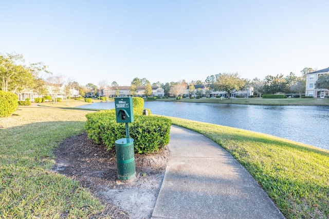 surrounding community featuring a water view, a residential view, and a lawn