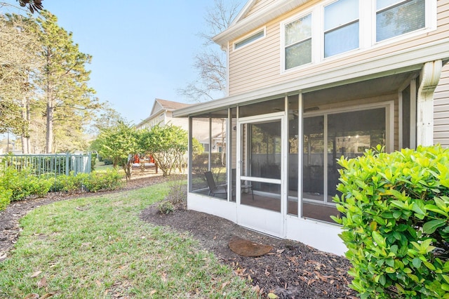 view of yard featuring fence and a sunroom