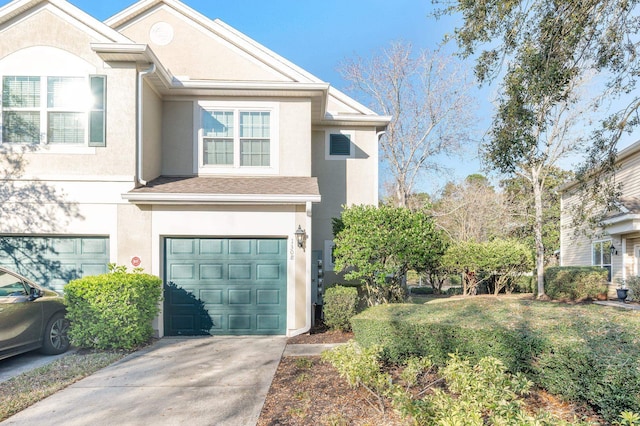 view of front of property with driveway, a garage, a front lawn, and stucco siding