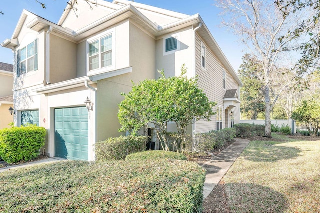 view of front of home featuring a garage, fence, and stucco siding