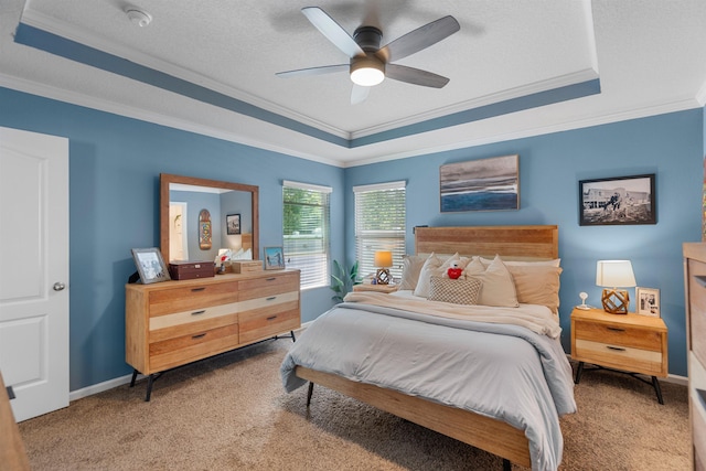 carpeted bedroom with a ceiling fan, a raised ceiling, and ornamental molding