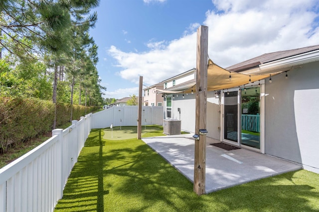 view of yard with central AC unit, a patio, and a fenced backyard