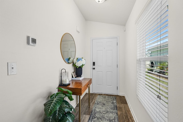 doorway featuring vaulted ceiling, wood finished floors, and baseboards