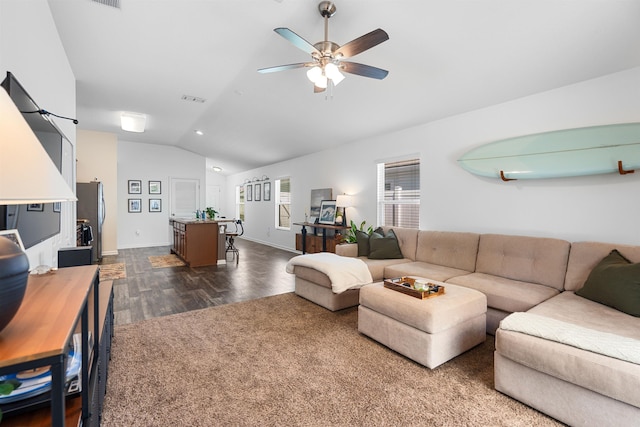 living room featuring visible vents, baseboards, dark wood-style flooring, ceiling fan, and lofted ceiling