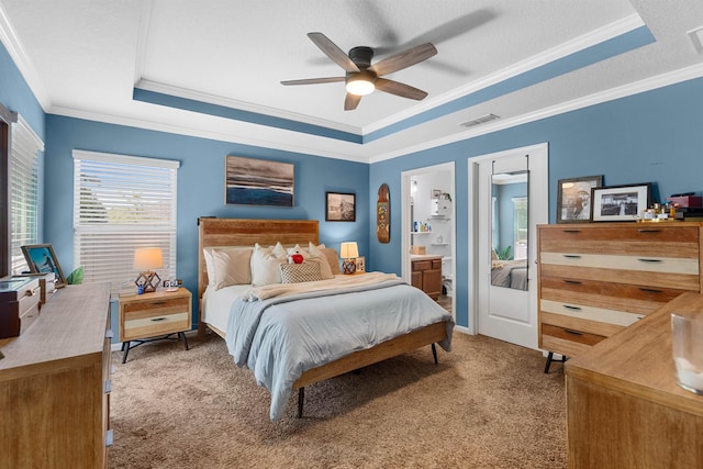 bedroom with a raised ceiling, crown molding, visible vents, and carpet