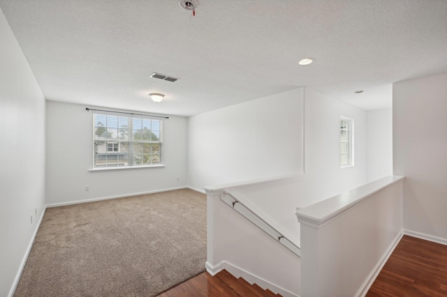 interior space featuring a textured ceiling, wood finished floors, and baseboards