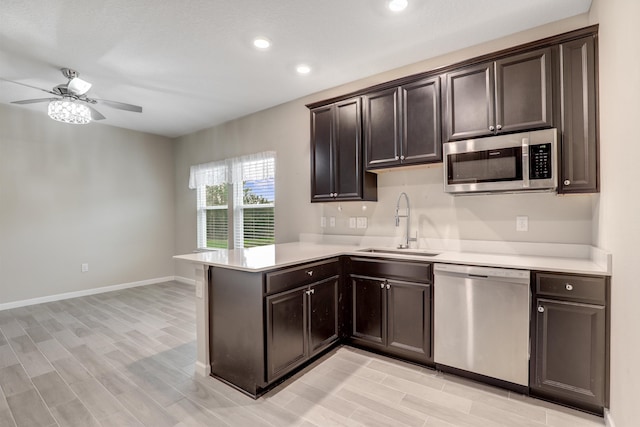 kitchen featuring dark brown cabinetry, ceiling fan, sink, kitchen peninsula, and appliances with stainless steel finishes