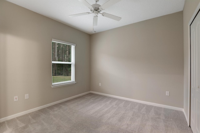 unfurnished room with light colored carpet and ceiling fan