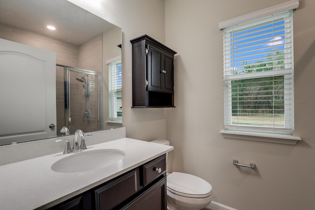 bathroom featuring vanity, toilet, and a shower with shower door