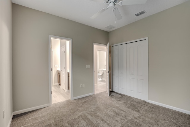 unfurnished bedroom featuring ceiling fan, light colored carpet, connected bathroom, and a closet