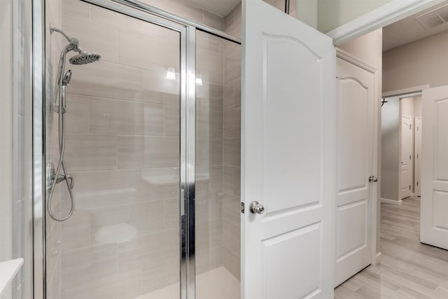 bathroom featuring an enclosed shower and wood-type flooring