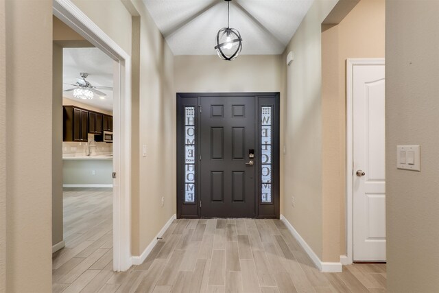 foyer entrance featuring ceiling fan, light hardwood / wood-style floors, and lofted ceiling