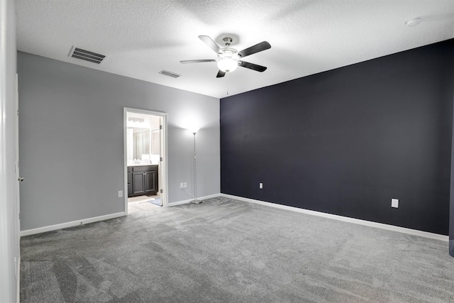 unfurnished bedroom with carpet flooring, connected bathroom, ceiling fan, and a textured ceiling