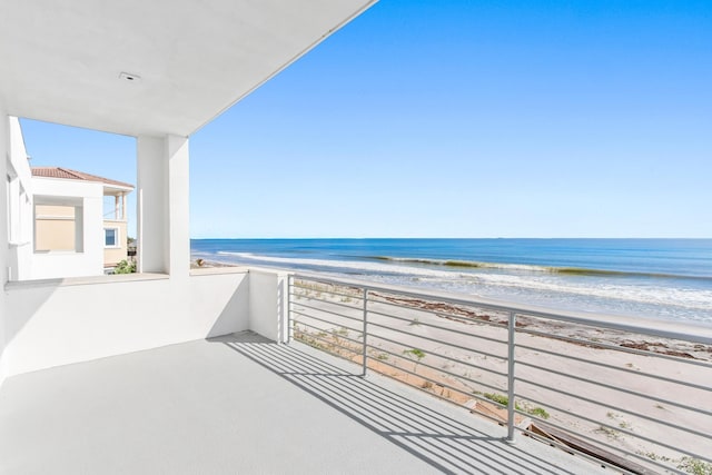 balcony with a beach view and a water view