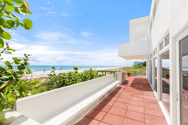 balcony featuring a water view and a beach view