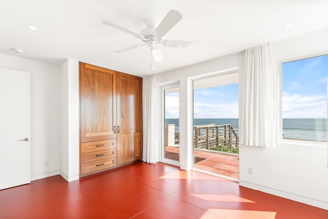 interior space with ceiling fan and a water view