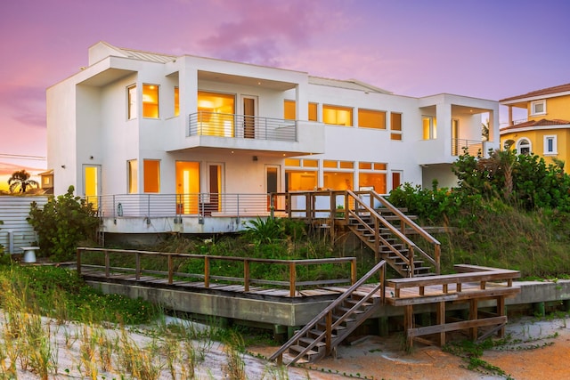 back house at dusk with a balcony