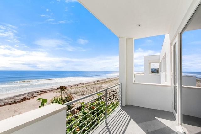 balcony featuring a beach view and a water view