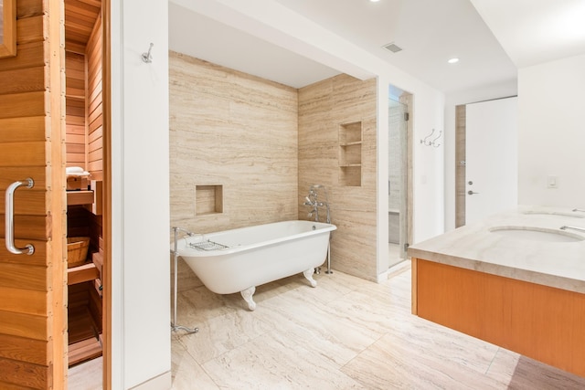 bathroom featuring vanity, separate shower and tub, and tile walls