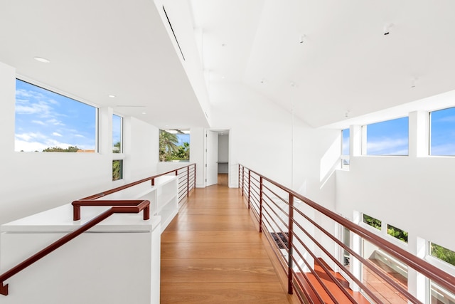 hall featuring light hardwood / wood-style floors and high vaulted ceiling