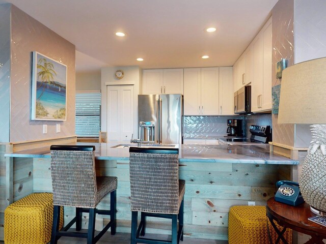 301 Premier Vista Way, Saint Augustine, FL 32080 - kitchen featuring a sink, electric range oven, stainless steel fridge with ice dispenser, white cabinetry, and a peninsula