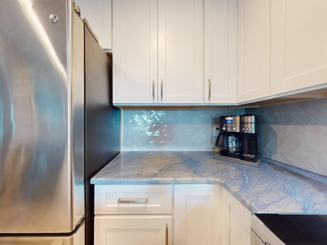 301 Premier Vista Way, Saint Augustine, FL 32080 - kitchen with white cabinetry, stove, decorative backsplash, and freestanding refrigerator