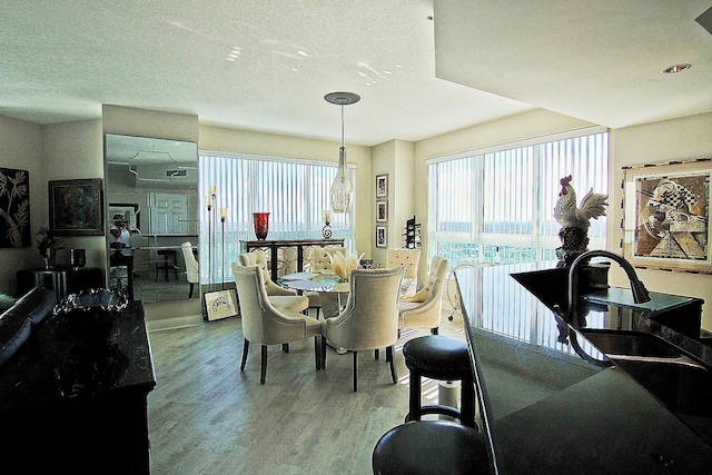 dining space with hardwood / wood-style flooring and a textured ceiling