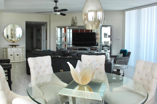 dining space with light carpet and ceiling fan