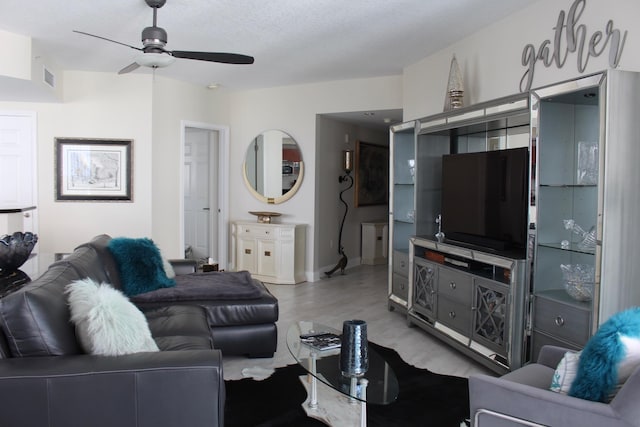 living room featuring a textured ceiling and ceiling fan