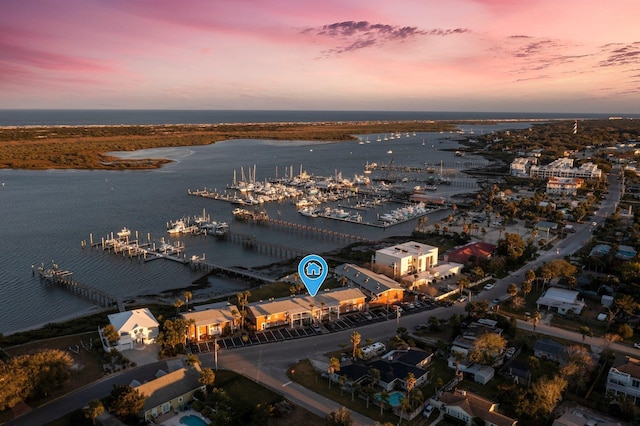 aerial view at dusk featuring a water view