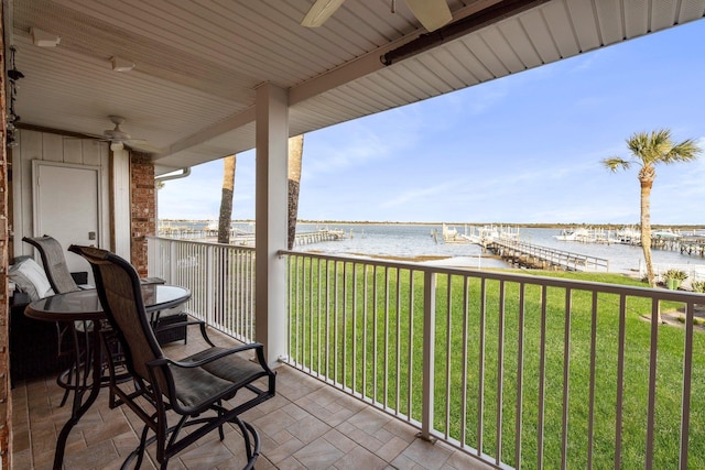 balcony featuring a water view and ceiling fan