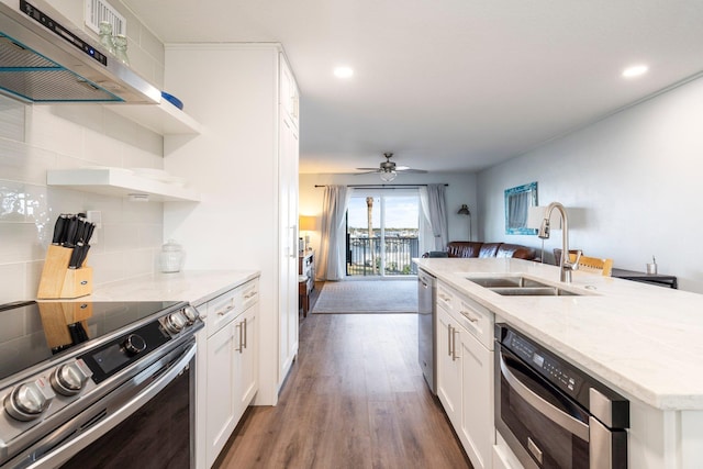 kitchen with extractor fan, sink, dark hardwood / wood-style floors, stainless steel appliances, and white cabinets