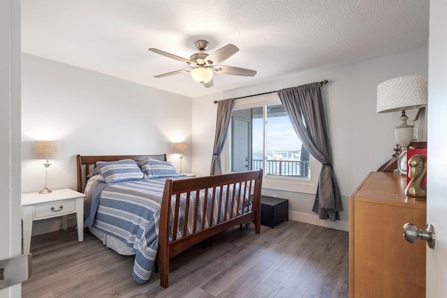 bedroom featuring a textured ceiling, dark hardwood / wood-style floors, and ceiling fan