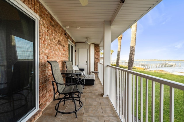 balcony featuring ceiling fan and a water view