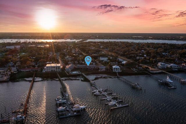 aerial view at dusk featuring a water view