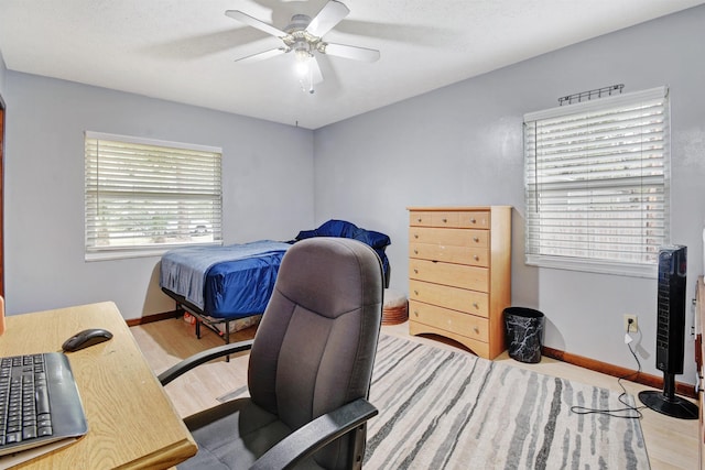 bedroom featuring ceiling fan, wood-type flooring, and multiple windows