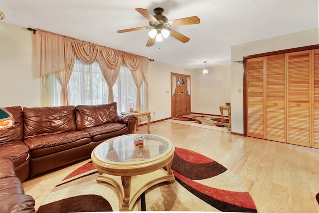 living room with ceiling fan and light hardwood / wood-style flooring