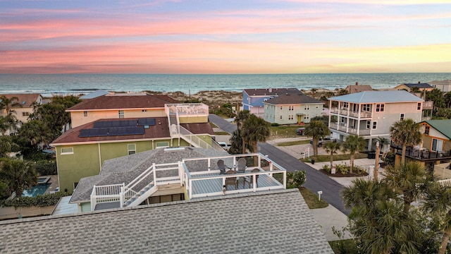 aerial view at dusk featuring a water view