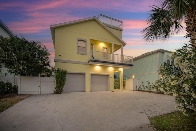 view of front of property featuring a balcony and a garage