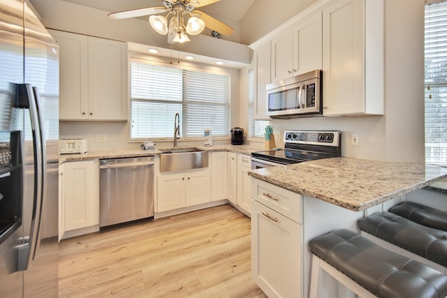 kitchen featuring a wealth of natural light, white cabinets, and stainless steel appliances