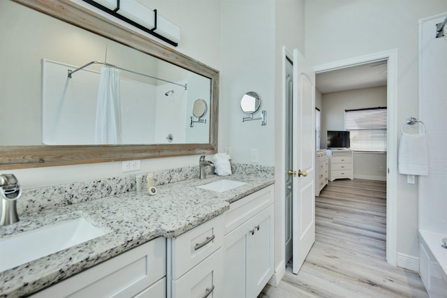 bathroom with shower / bathtub combination with curtain, vanity, and wood-type flooring