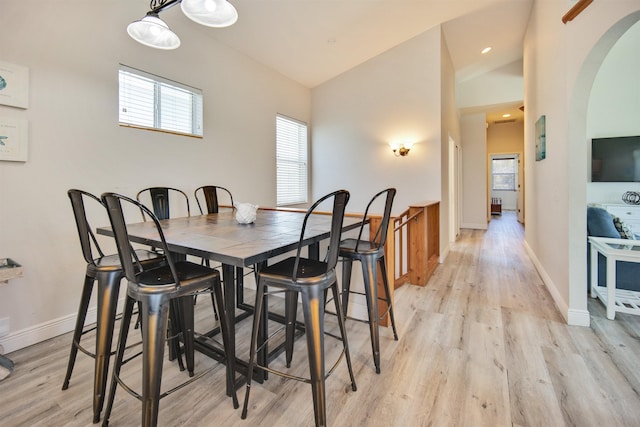 dining room with light hardwood / wood-style floors and vaulted ceiling