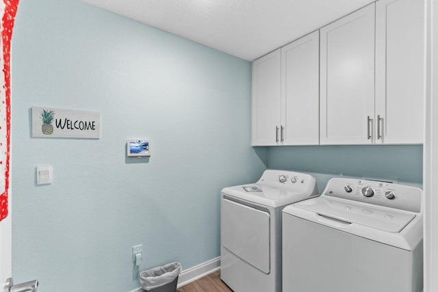 washroom with separate washer and dryer, light hardwood / wood-style flooring, and cabinets