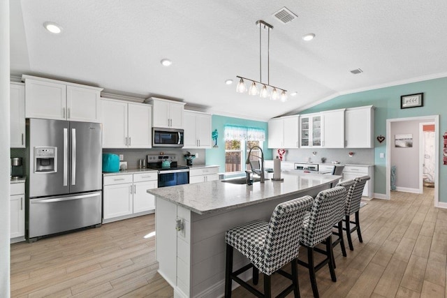 kitchen with white cabinetry, an island with sink, stainless steel appliances, and sink