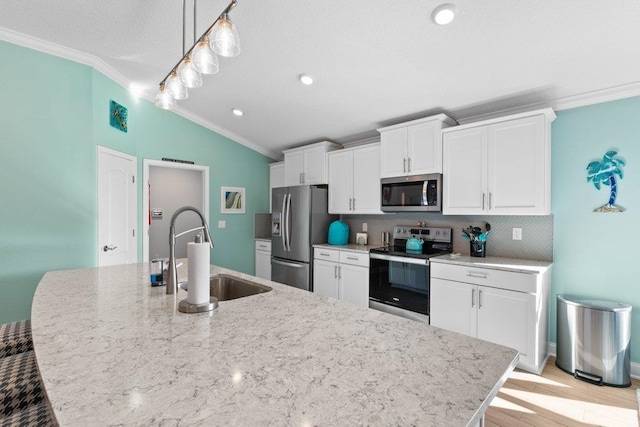 kitchen with lofted ceiling, sink, crown molding, decorative light fixtures, and stainless steel appliances