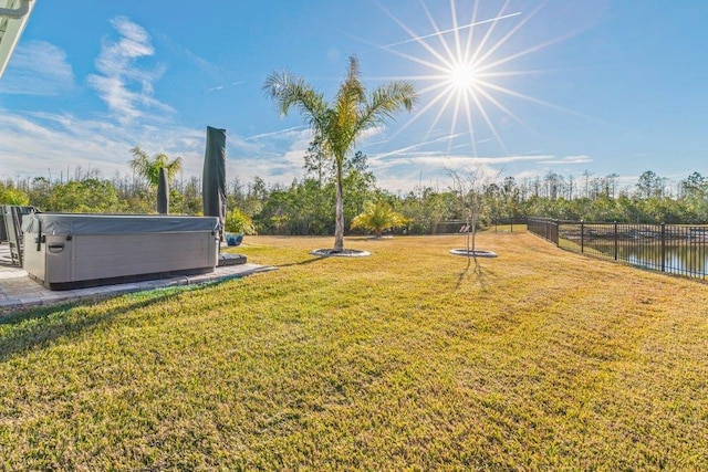 view of yard featuring a water view and a hot tub