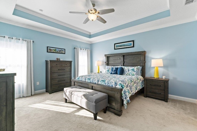 bedroom featuring crown molding, light colored carpet, and a raised ceiling